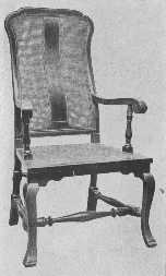 A reproduction of a walnut chair with cane seat and
back, of the William and Mary period.