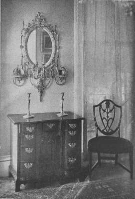 A valuable collection of an Adam mirror, a block-front,
 knee-hole chest of drawers, and a Hepplewhite chair.