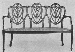 A modern Hepplewhite settee, showing the draped scarf
 carving he used so much.