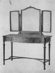 The modern style of mirror is brought into harmony with
the eighteenth century dressing-table by means of carving.