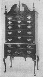 The general proportions, the broken pediment and torch or
flame ornaments and drops, large brasses, and cabriole legs all show
that this splendid example of a highboy belongs to the same time as the
desk, about 1750.